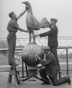 17th July 1934:  The nine foot high cockerel, which normally sits above the stands at Tottenham Hotspur's ground in White Hart Lane, being cleaned whilst the stands are improved and enlarged.  (Photo by R. Wesley/Fox Photos/Getty Images)